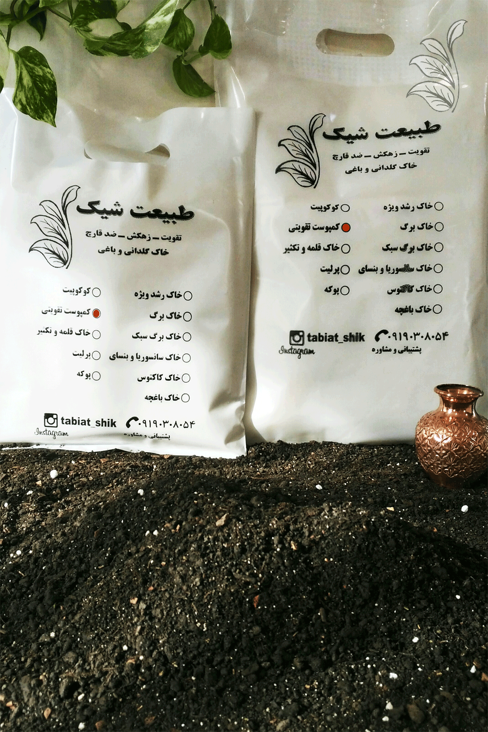 "دو بسته کمپوست تقویتی ارگانیک طبیعت شیک روی یک سطح چوبی، همراه با یک گلدان مسی کوچک و شاخه‌ای از گیاه پتوس که فضایی طبیعی و زیبا ایجاد کرده‌اند."