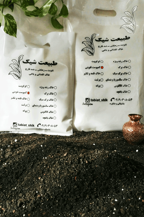 "دو بسته کمپوست تقویتی ارگانیک طبیعت شیک روی یک سطح چوبی، همراه با یک گلدان مسی کوچک و شاخهای از گیاه پتوس که فضایی طبیعی و زیبا ایجاد کردهاند."