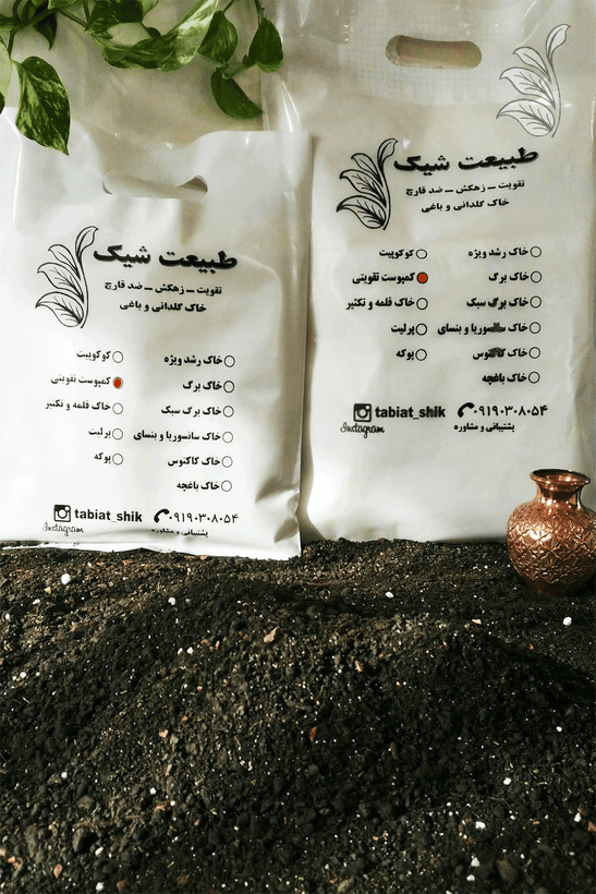 "دو بسته کمپوست تقویتی ارگانیک طبیعت شیک روی یک سطح چوبی، همراه با یک گلدان مسی کوچک و شاخهای از گیاه پتوس که فضایی طبیعی و زیبا ایجاد کردهاند."